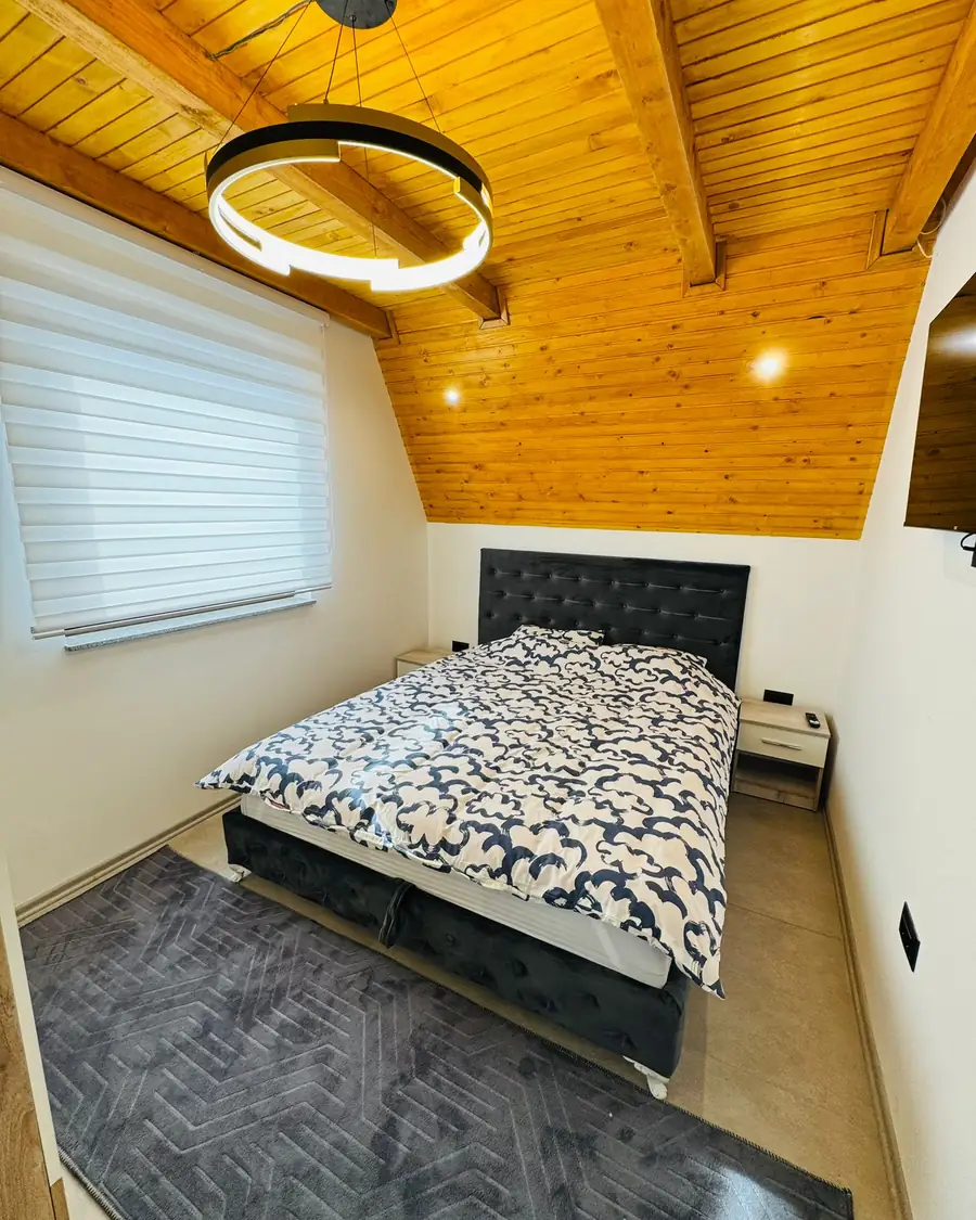 Spavaća soba sa drvenim stropom u vikendici Weekend House Vlašić
